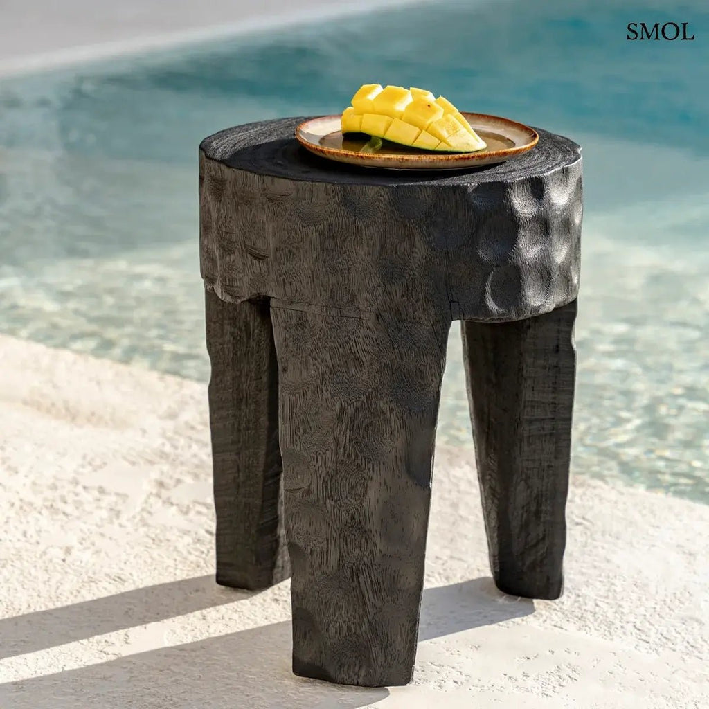 Kézzel faragott, fekete suar fa ülőke és lerakóasztal kalapált textúrával és három masszív lábbal, modern és egzotikus stílusú enteriőrhöz, mangóval, medencénél
