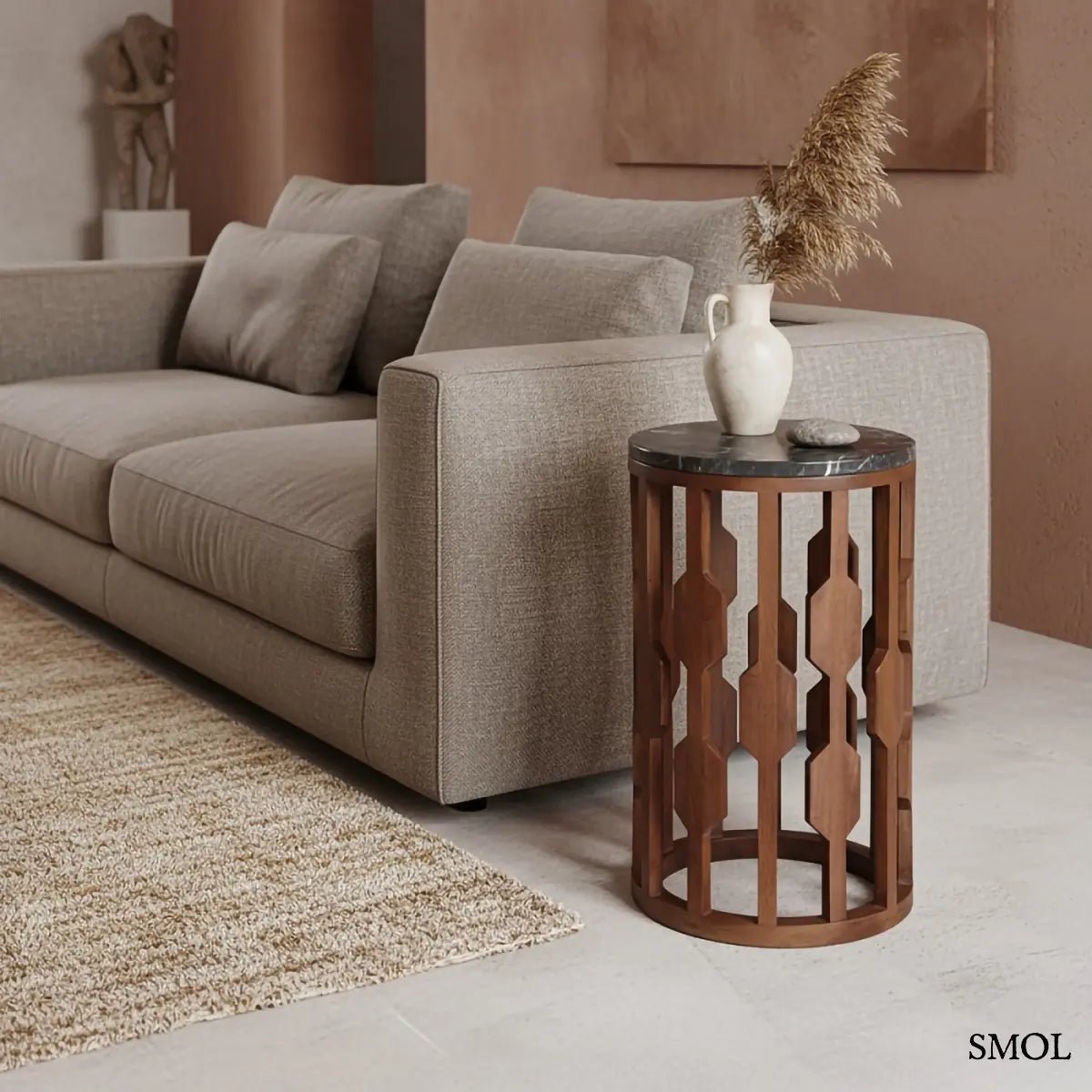 Fekete márványlapos lerakóasztal antik barna mangófa vázzal, henger alakú kisasztal modern és japandi stílusban szürke kanapé mellett, fűvel