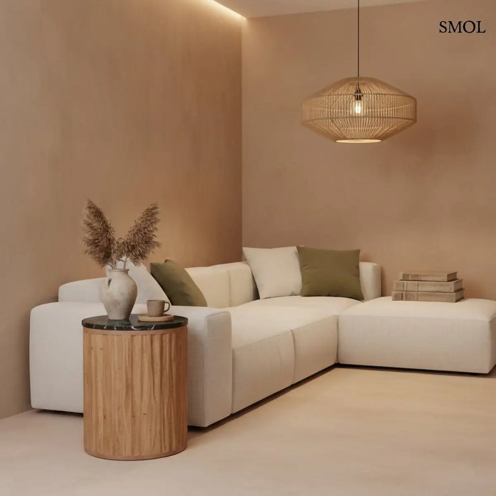 Kerek lerakóasztal fekete márvány asztallappal és függőlegesen barázdált, természetes barna mangófa talppal, nappaliban, kanapé mellett