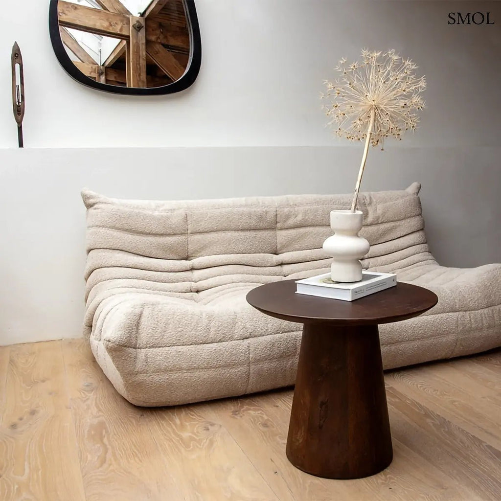 Modern, sötétbarna tömör mangófa lerakóasztal robusztus kúp alakú talppal és kerek asztallappal, nappaliban, száraz virággal