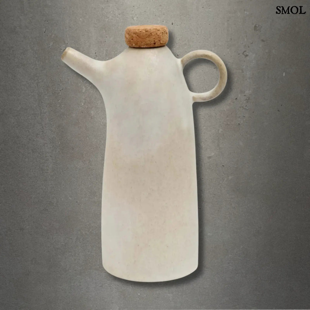 Kézműves fehér kerámia olívaolaj-kiöntő palack parafa dugóval, cseppmentes kiöntőcsőrrel, szürke háttérrel
