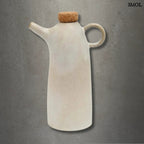 Kézműves fehér kerámia olívaolaj-kiöntő palack parafa dugóval, cseppmentes kiöntőcsőrrel, szürke háttérrel