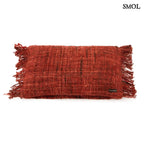 Bohém stílusú, cseresznyepiros párnahuzat rojtos szegéllyel fehér háttérrel