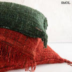 Zöld díszpárnahuzat piros párnákkal