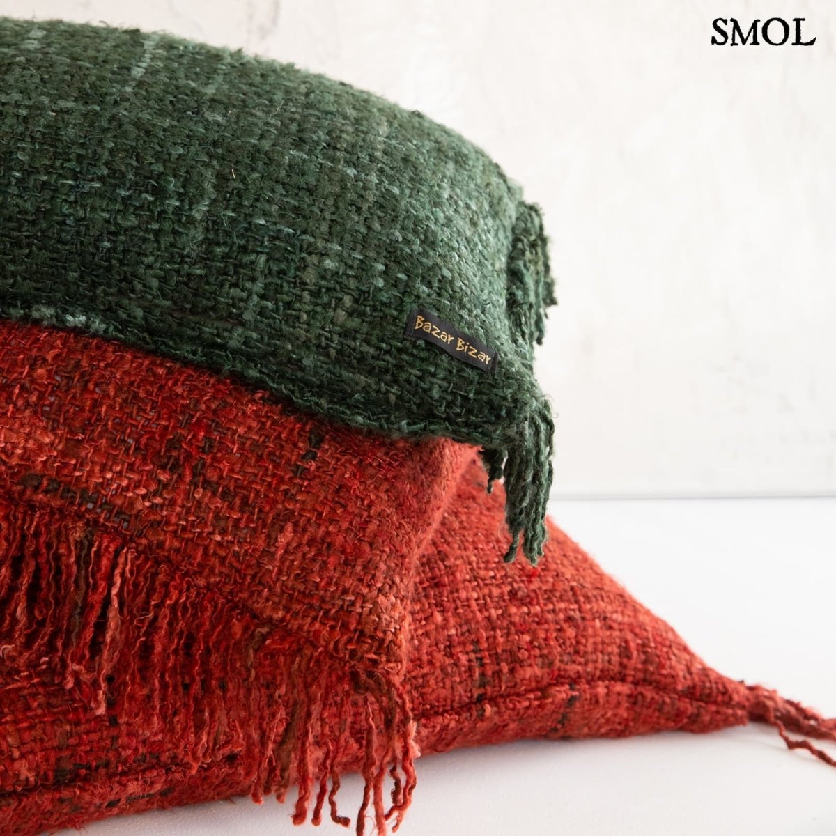 Zöld díszpárnahuzat piros párnákkal