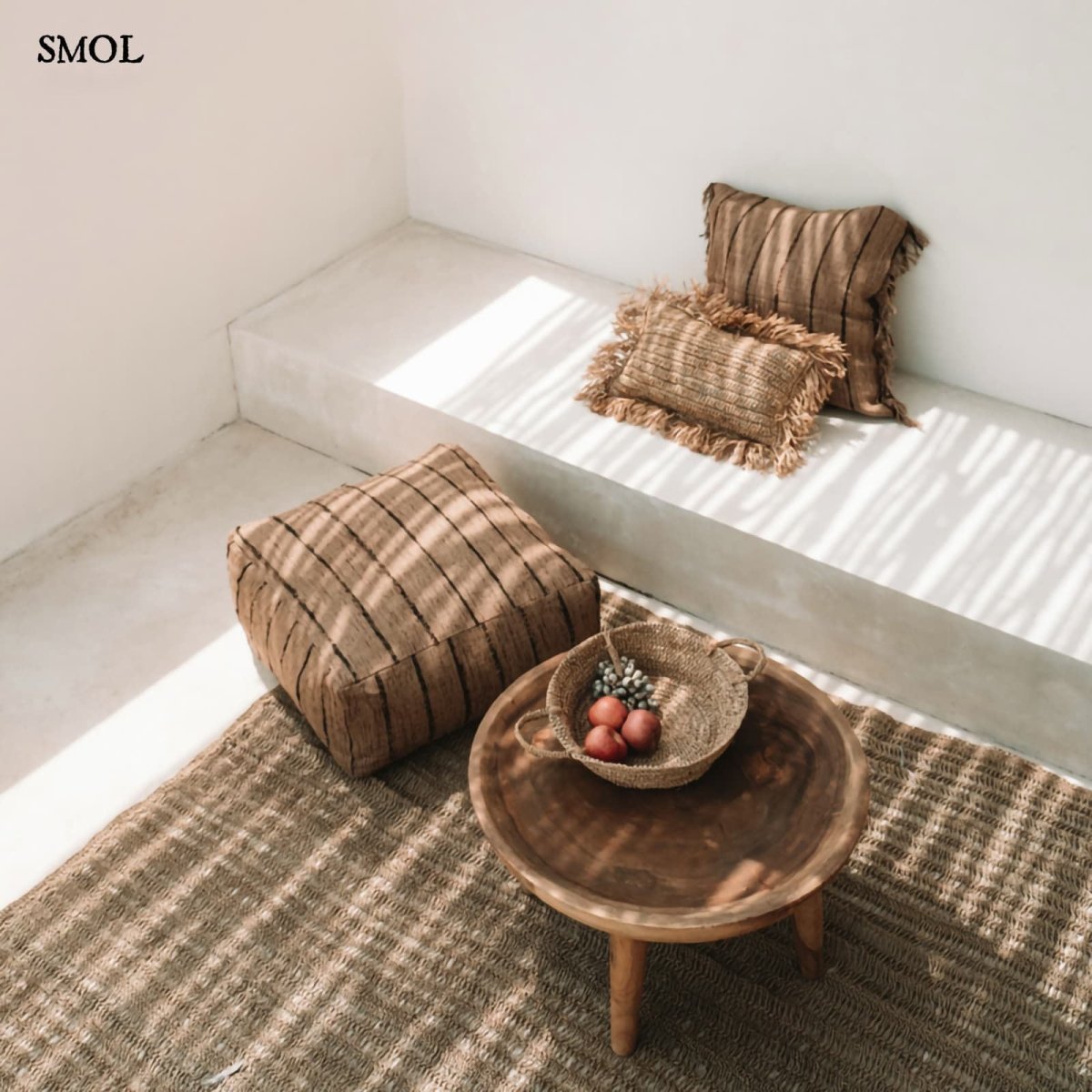 Bézs és fekete csíkos díszpárnahuzat rojtokkal nappaliban puffal és kisasztallal