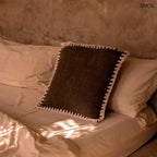 Barna pamut díszpárnahuzat fehér kézi horgolású szegéllyel, 50x50 cm-es méretben, ágyon