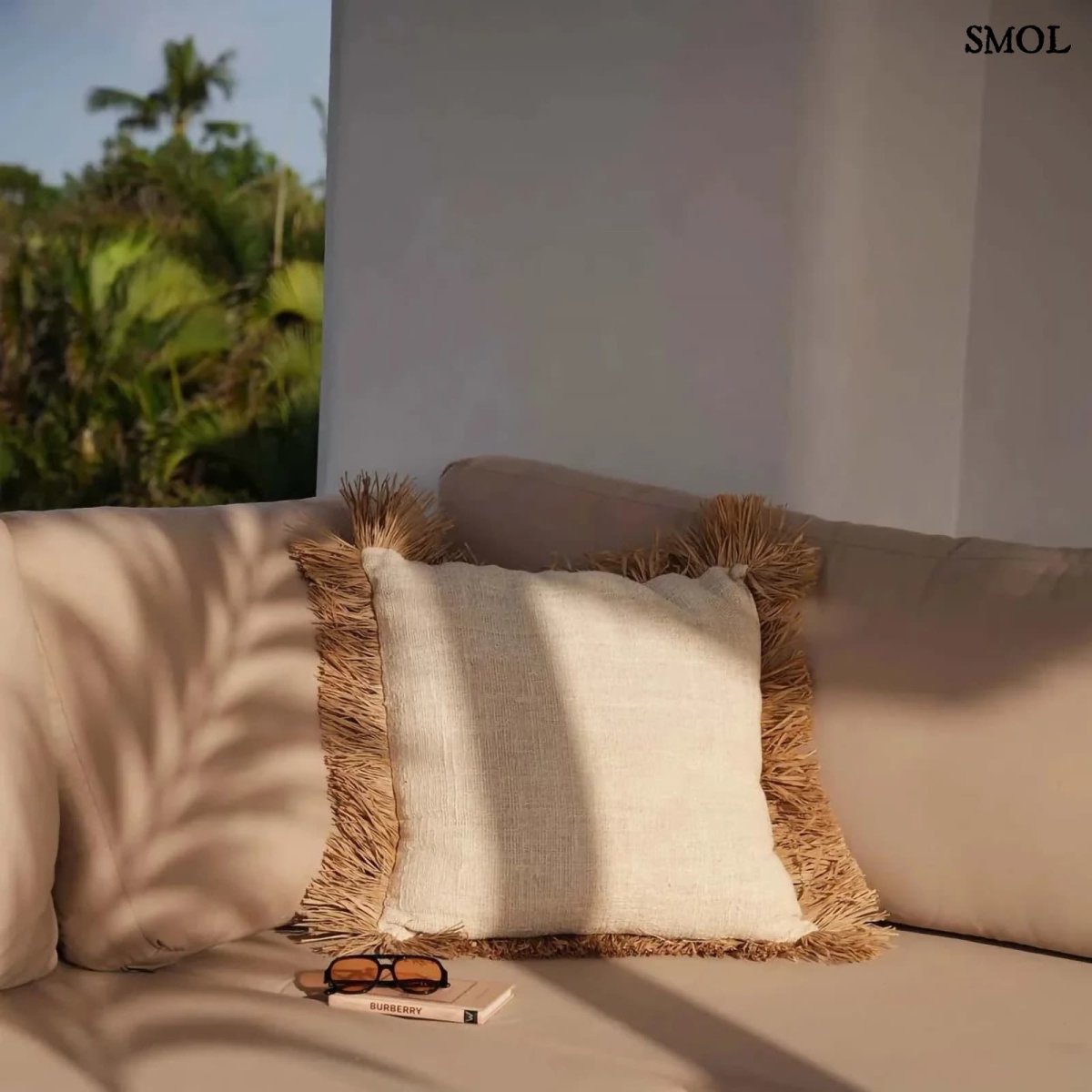 Fehér pamut és raffia díszpárnahuzat rojtokkal teraszon, kanapén