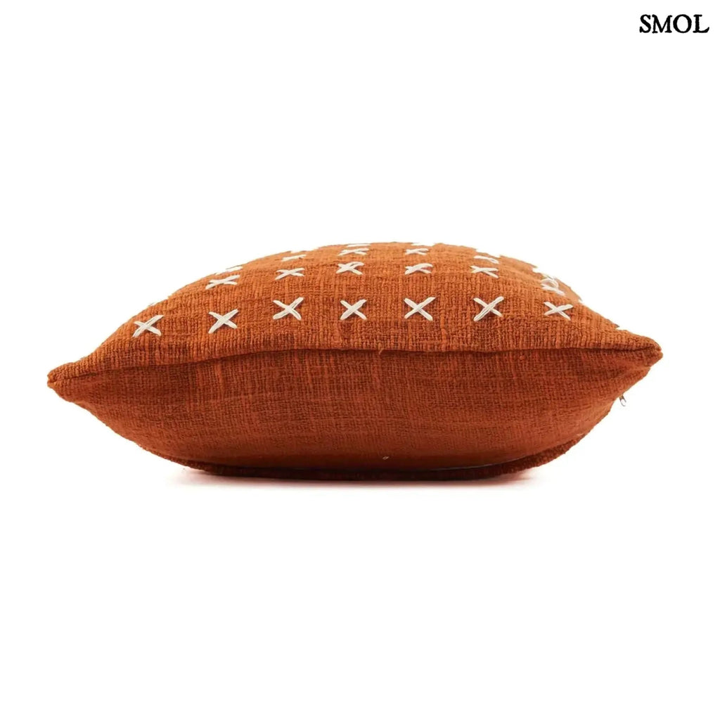 Pamut díszpárnahuzat, élénk terrakotta színben, sűrűn elhelyezett, kézzel varrott fehér kereszt mintákkal, fektetve