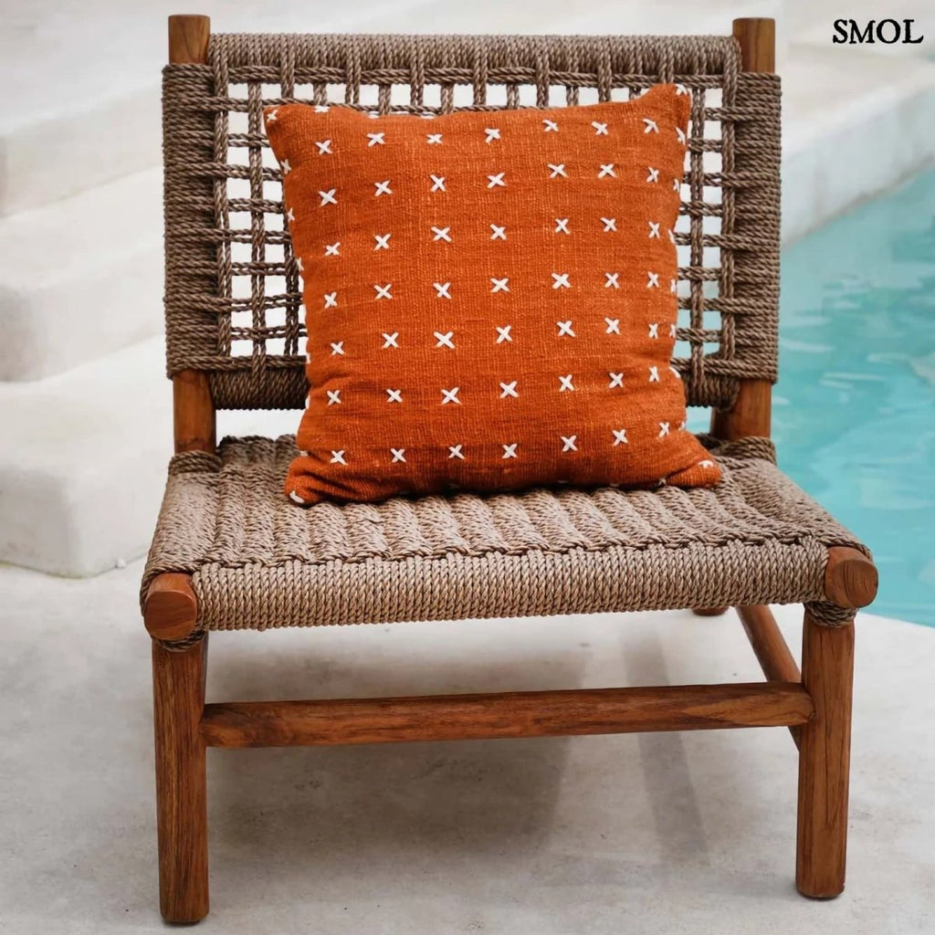 Pamut díszpárnahuzat, élénk terrakotta színben, sűrűn elhelyezett, kézzel varrott fehér kereszt mintákkal, széken