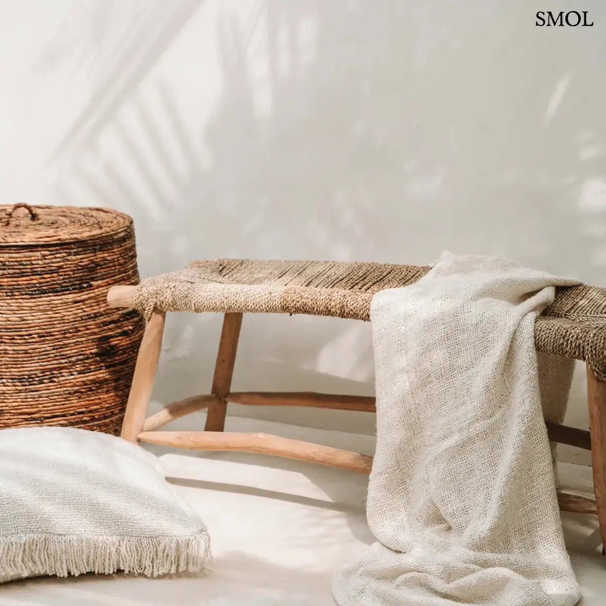 Kézzel szőtt, krémfehér pamut pléd gofri struktúrával és rojtokkal díszítve, padon