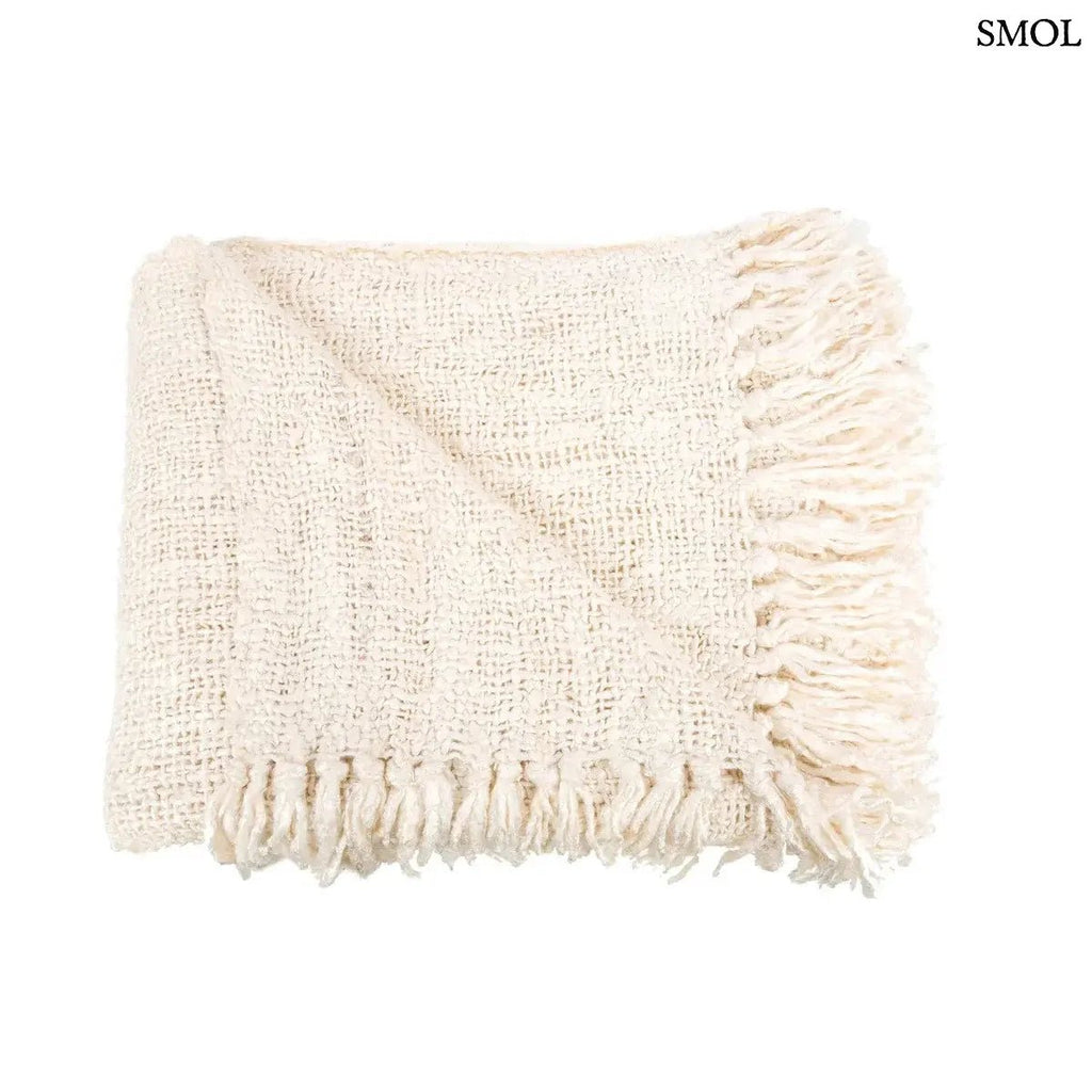 Kézzel szőtt, krémfehér pamut pléd gofri struktúrával és rojtokkal díszítve, összehajtva