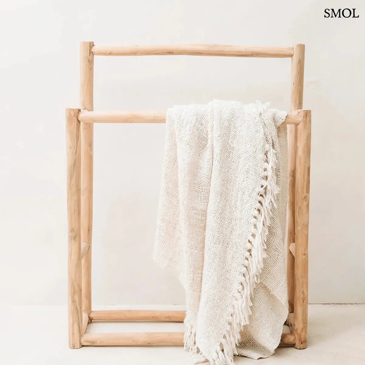 Kézzel szőtt, krémfehér pamut pléd gofri struktúrával és rojtokkal díszítve, törölközőtartón