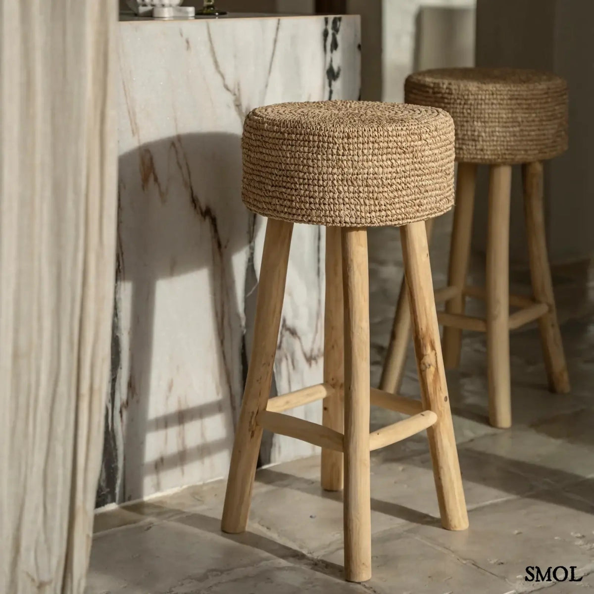 Raffia bárszék natúr színben, kézzel fonott ülőfelülettel és fa lábakkal, két szék teraszon