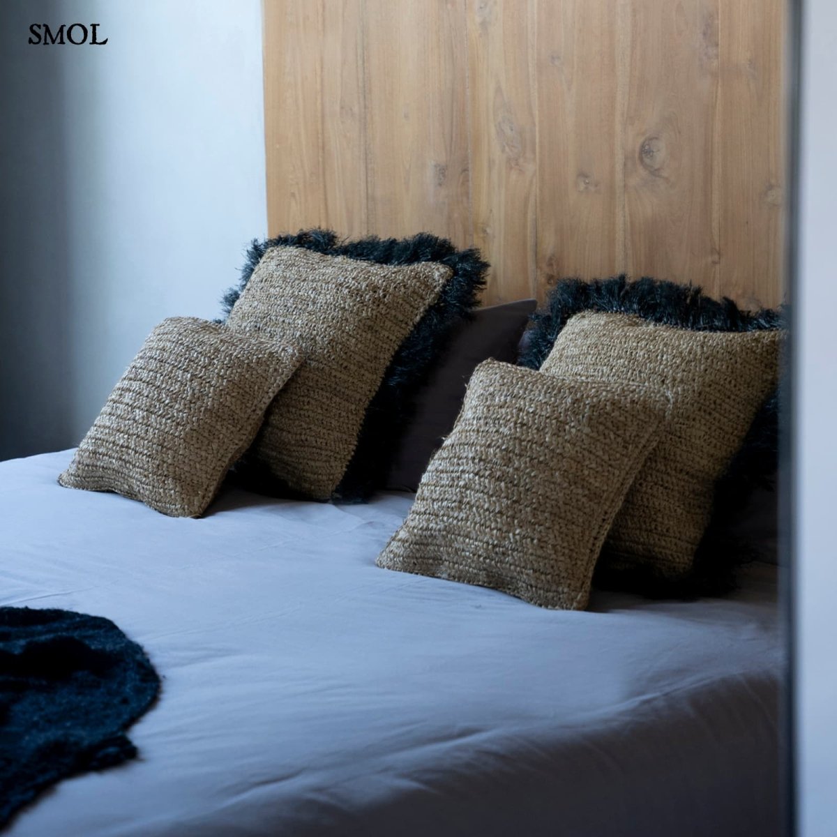 Natúr színű, kézzel szőtt raffia díszpárnahuzat boho stílusban hálószobában, ágyon