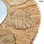 Kézzel készült boho raffia fali tükör 60 cm-es méretben, natúr színben, apró kagylókkal és levél mintával díszítve, nagyítva