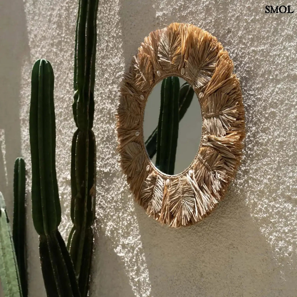 Kézzel készült boho raffia fali tükör 60 cm-es méretben, natúr színben, apró kagylókkal és levél mintával díszítve, kültéren, ferdén
