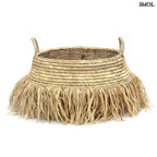 Raffia tárolókosár natúr színben, rojtos boho díszítéssel, fehér háttérrel