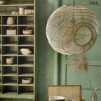 Aszimmetrikus gömb alakú, kézzel font natúr rattan függőlámpa fekete kábellel, zöld étkezőben