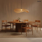 Organikus, hullámos vonalvezetésű natúr rattan függőlámpa kézzel szőtt textúrával és fekete kábellel, modern és bohém stílusú terekhez, étkezőasztal felett, világító égővel