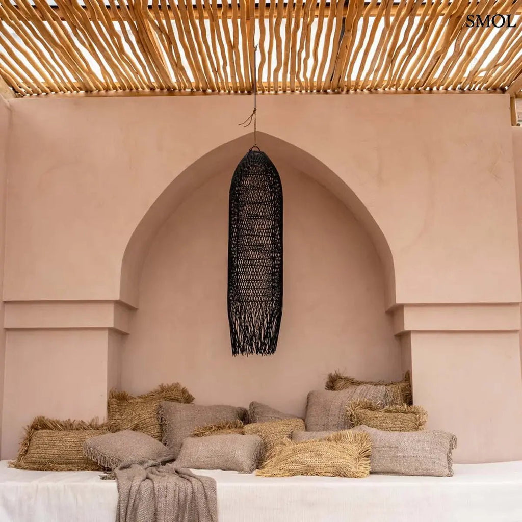 Hosszúkás, kézzel font fekete rattan függőlámpaernyő, teraszon, párnákkal