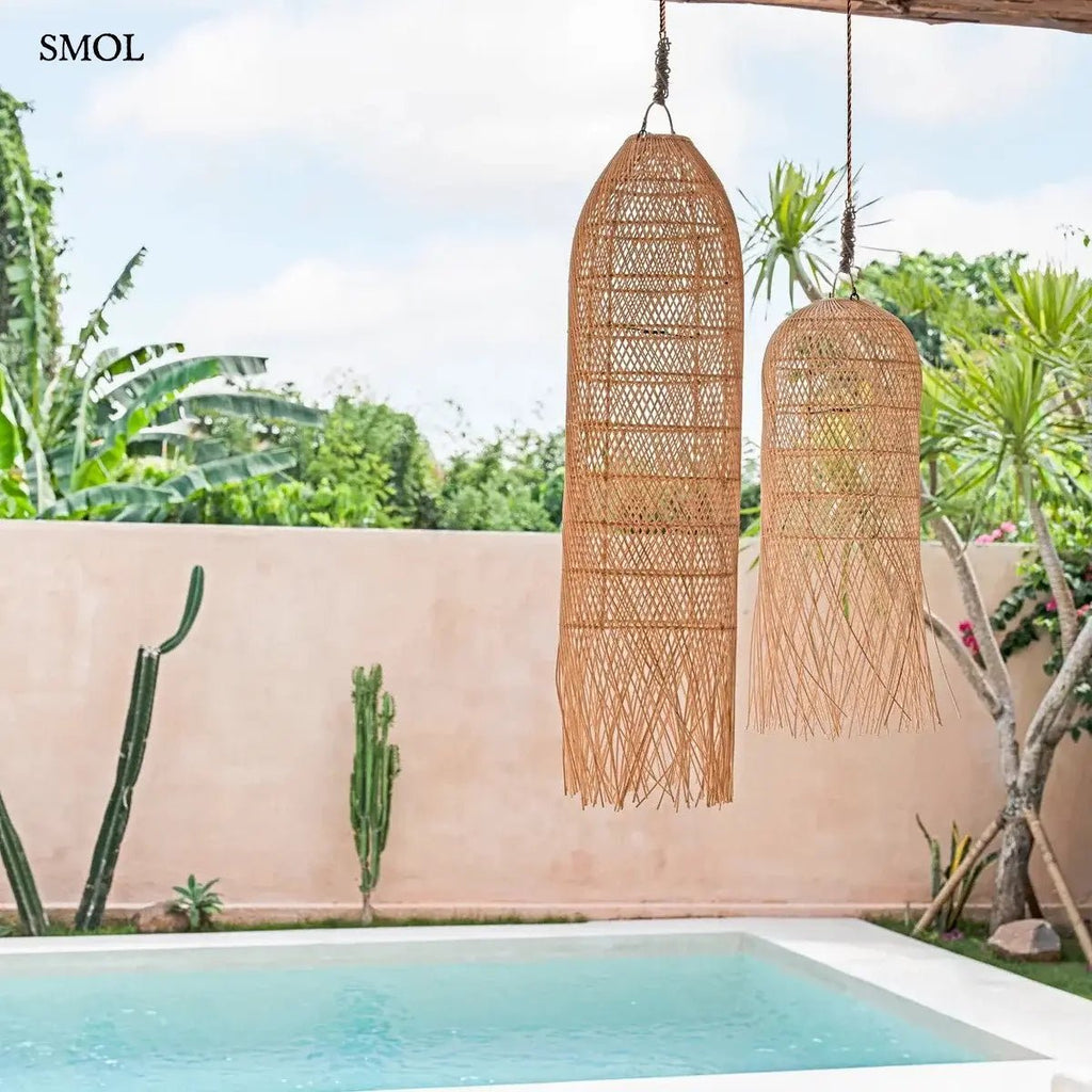 Kézzel szőtt, natúr színű, hosszúkás rattan függőlámpaernyő, alján lelógó, organikus szálakkal, teraszon