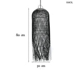 Hosszúkás, fekete színű, kézzel szőtt rattan lámpaernyő, amelynek alján a szálak szabadon, ritmikus vonalakkal végződnek, méretekkel
