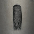 Hosszúkás, fekete színű, kézzel szőtt rattan lámpaernyő, amelynek alján a szálak szabadon, ritmikus vonalakkal végződnek, szürke háttérrel