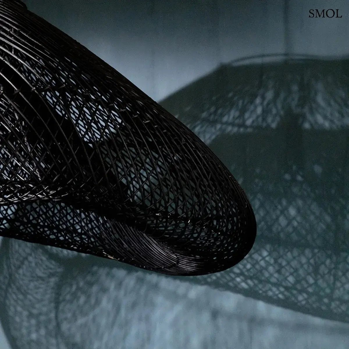 XXL méretű, fekete színű, kézzel szőtt rattan lámpaernyő hullámzó, organikus felhő formával és finom textúrával, falra vetített árnyékokkal