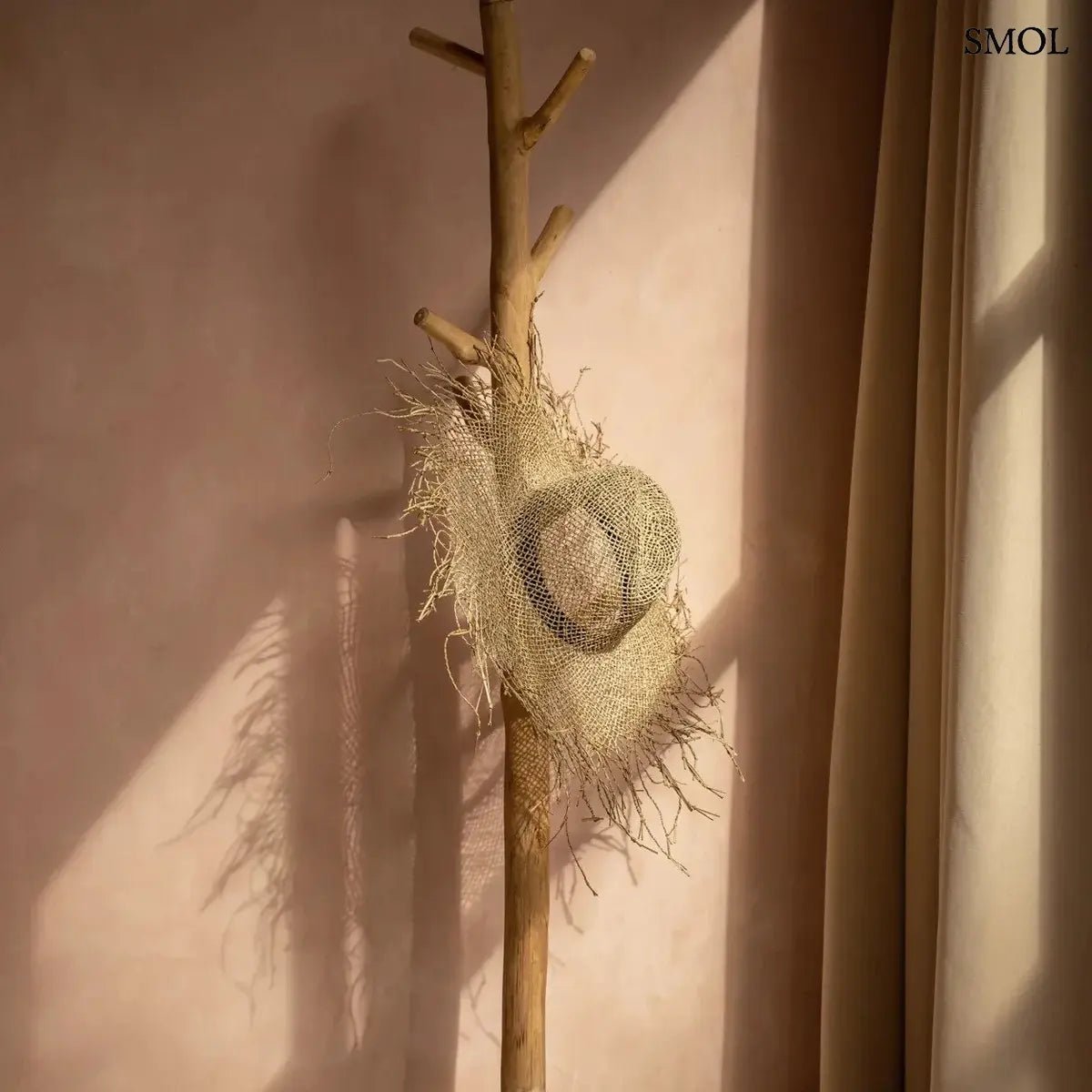 Kézzel szőtt, rusztikus tengerifű szalmakalap rojtos széllel és természetes textúrával a strandoláshoz, akasztón