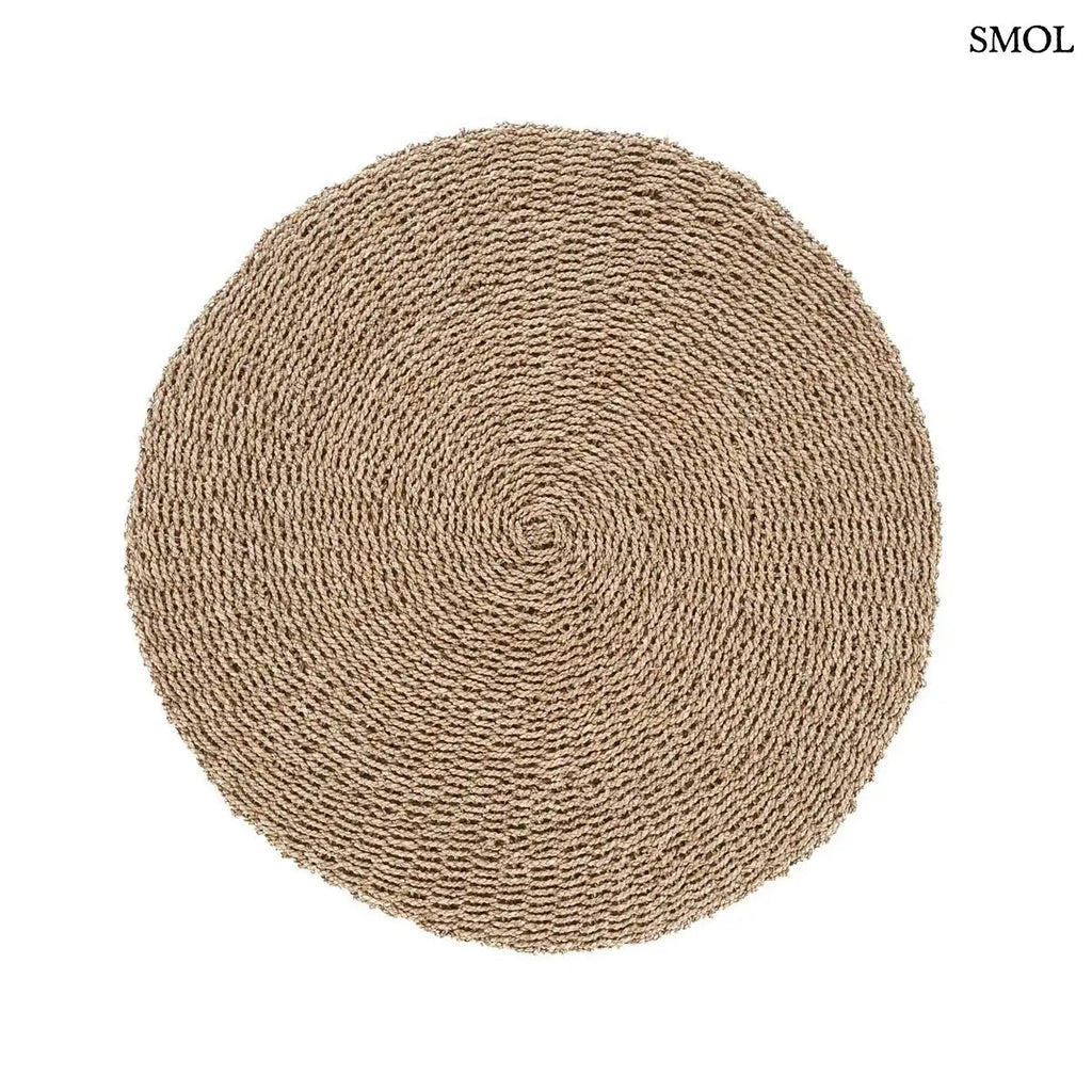 Természetes szizál szőnyeg kerek formában, kézzel font textúrával, homokszínű boho stílusban, fehér háttérrel, kiterítve