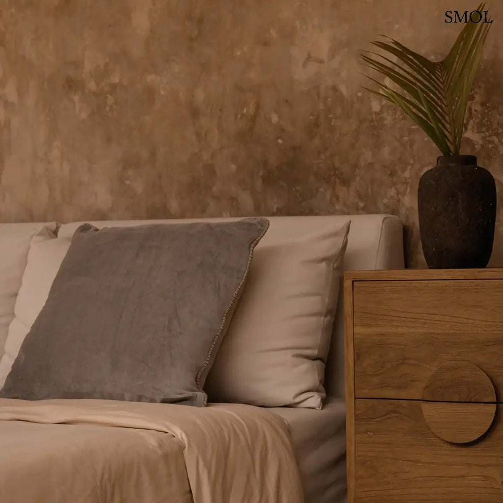 Szürke bársony díszpárnahuzat 50x50 cm méretben, elegáns fonott szegéllyel, hálószobában, vázával