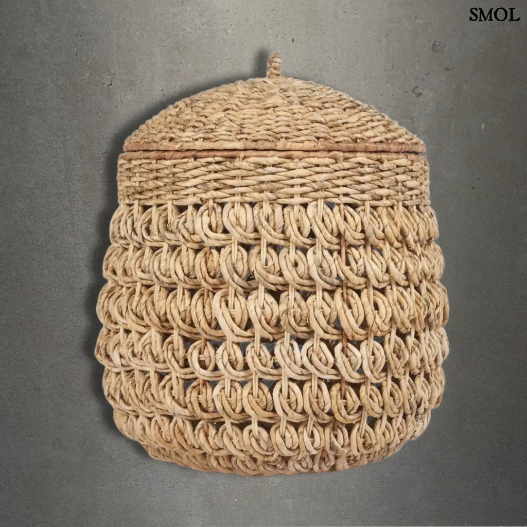 Kézzel fonott banánlevél tároló kosár fedővel, természetes natúr színben. Magas, kerek, szürke háttérrel