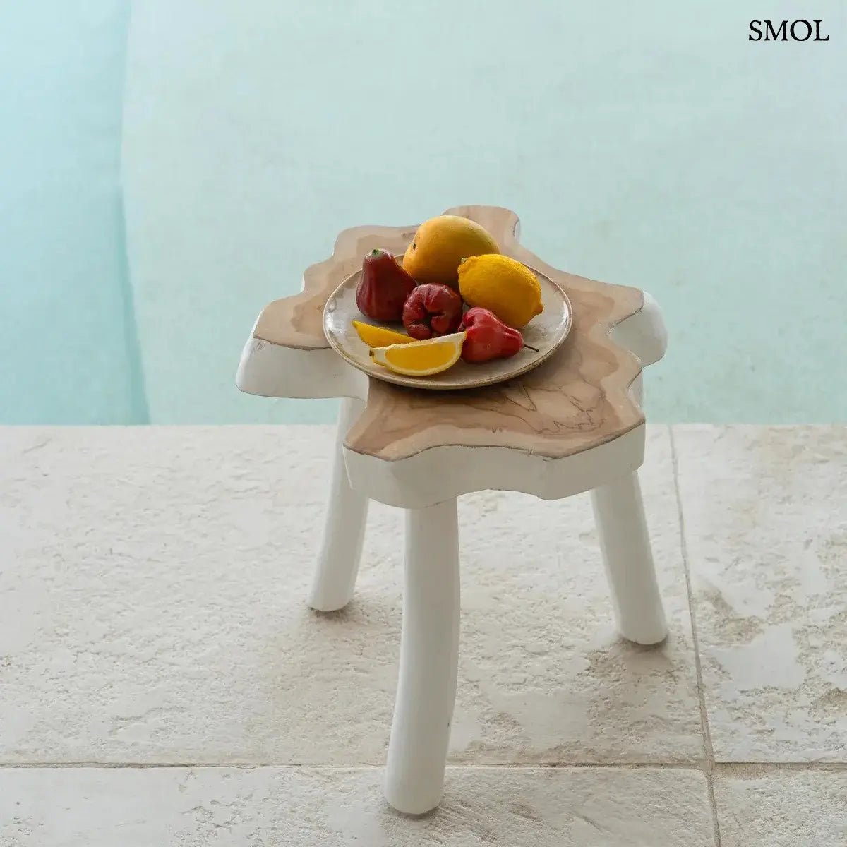 Háromlábú organikus teakfa lerakóasztal natúr fa tetővel és fehér lábakkal, bohém stílusban, gyümölcsökkel