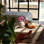 teakfa tortatál magasított talppal, natúr színben süteményekkel, puffon