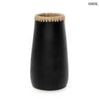 Fekete-natúr terrakotta váza felső részén fonott raffia díszítéssel, kézműves indonéz kerámia dekoráció, fehér háttérrel