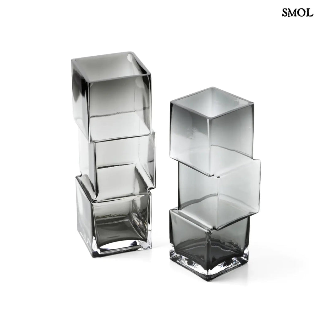 Függőlegesen elrendezett, három kocka alakú sötétszürke üveg váza, felülről