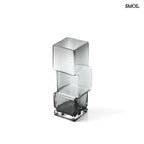 Függőlegesen elrendezett, három kocka alakú sötétszürke üveg váza, fehér háttérrel