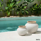 Rusztikus natúr terrakotta váza kézzel font raffia díszítéssel a peremén, két méretben, medence mellett