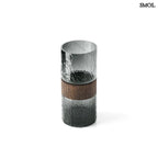 Sötétszürke textúrált üveg váza, barna fa berakással, felülről